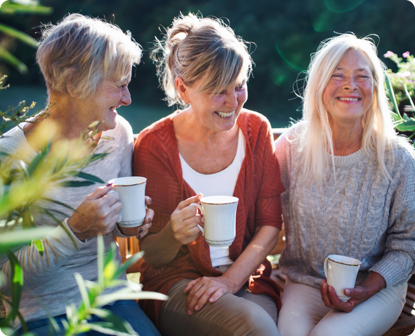 Three woman holding mugs and laughing
